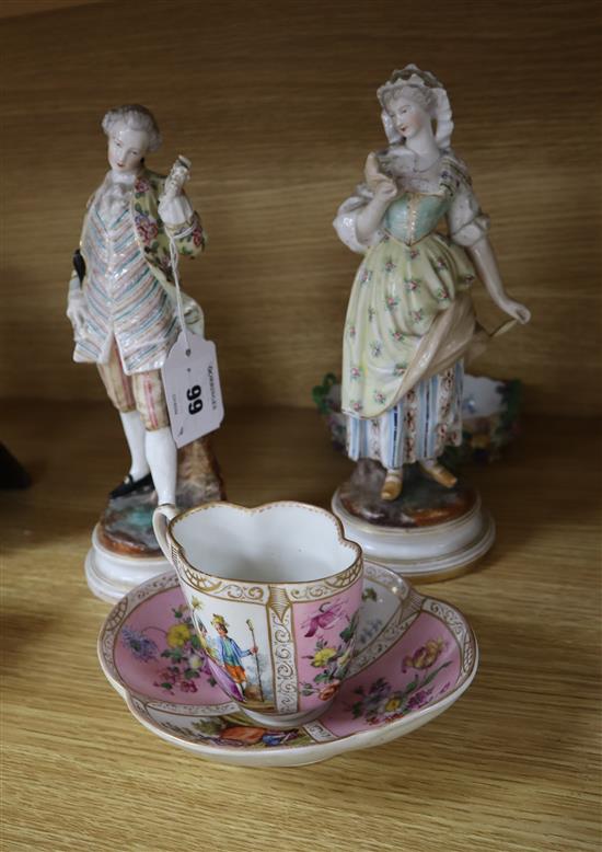 A pair of Dresden figures of a lady and gallant and a pink glazed cup and saucer and a dish tallest 24cm